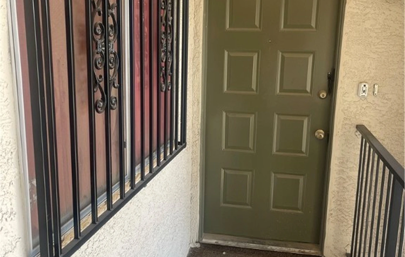 Condo Entrance With Green Door And Security Bars