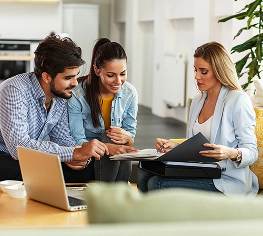 Couple Reviewing Documents With Real Estate Agent